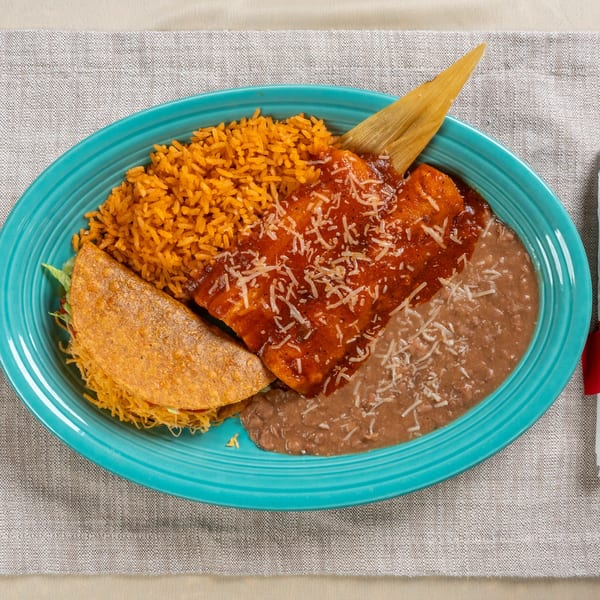 A Chavela's Mexican Cuisine combo plate with rice, beans, enchilada, taco, and a tamale husk.